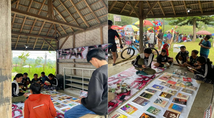 Community members engaging with a display of books in an outdoor covered structure